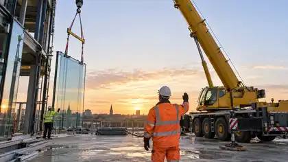 Illustrative Solar Window Film Surveys scene: Dawn crane lift of glass panels.png.